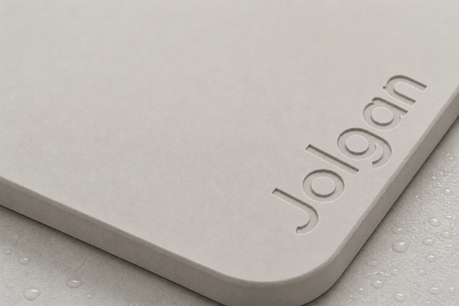 Real bath mat detail with the engraved JOLGAN logo